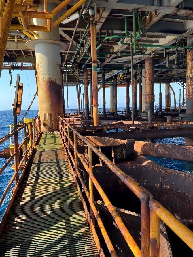 Ambiente industrial com tubulações e passarela
